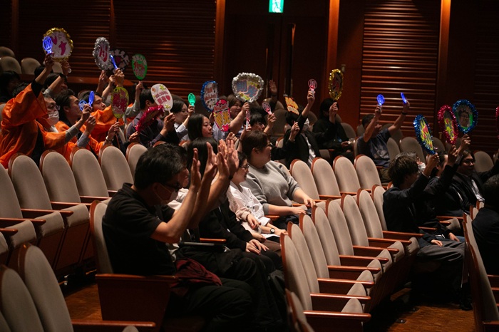 「推し活うちわ」を持って声援を送る社員